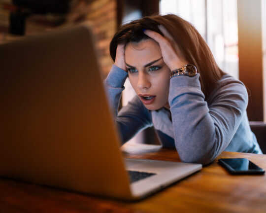 Woman looking at laptop trying to figure out something complex